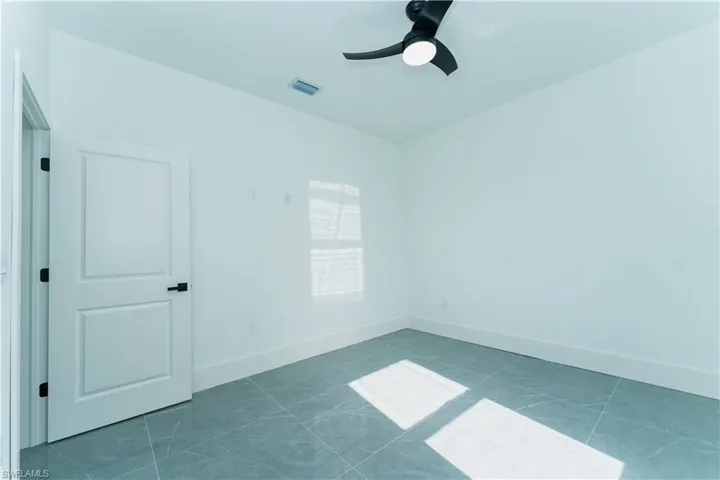 Empty room featuring ceiling fan and baseboards