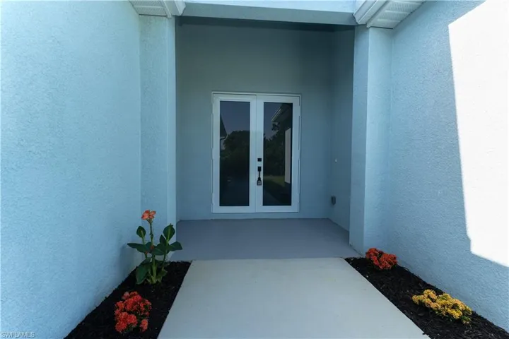 Doorway to property with french doors and stucco siding