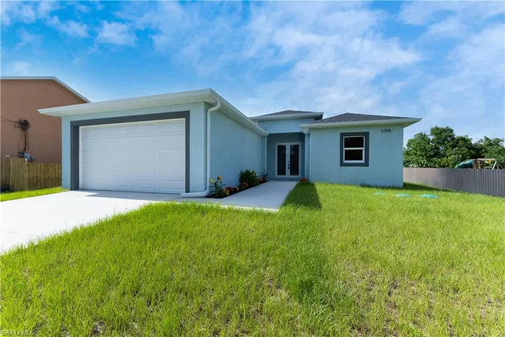 View of front of property with french doors, concrete driveway, stucco siding, and an attached garage