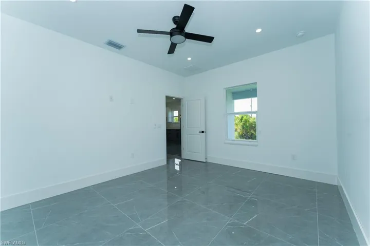 Empty room featuring baseboards and a ceiling fan