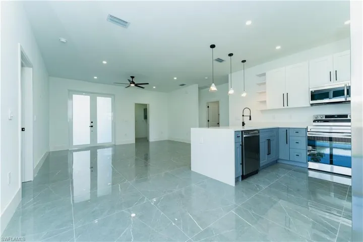 Kitchen featuring appliances with stainless steel finishes, open shelves, french doors, recessed lighting, and a peninsula