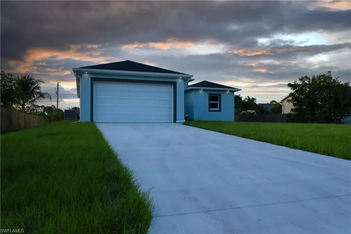 Single story home with central AC, concrete driveway, and stucco siding