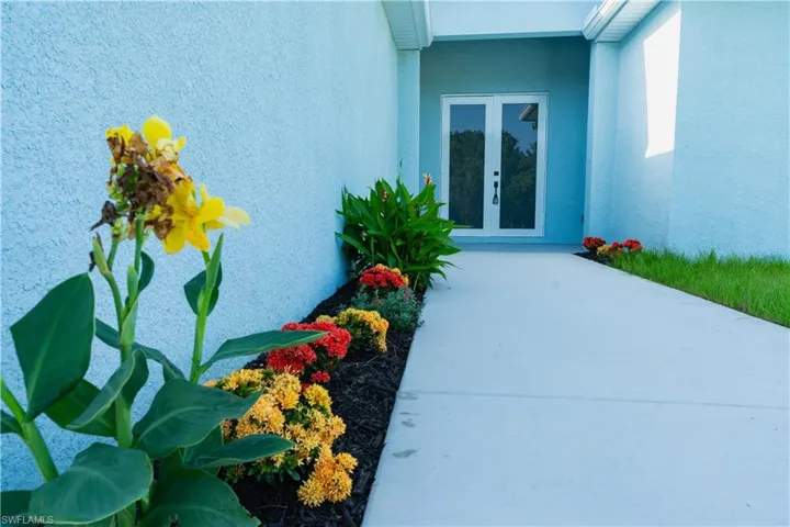 View of exterior entry with stucco siding and french doors