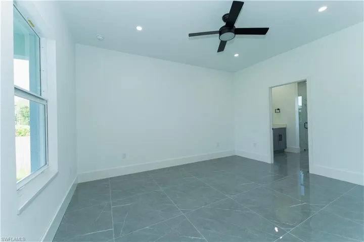 Empty room featuring recessed lighting, a ceiling fan, baseboards, and dark marble finish flooring
