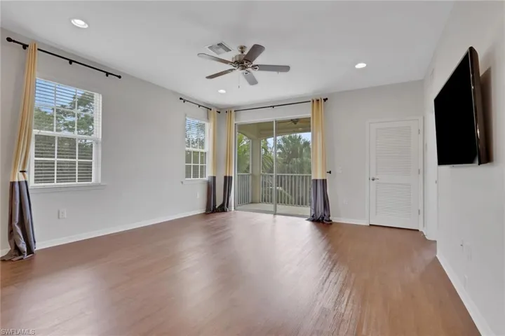 Spare room featuring plenty of natural light, wood finished floors, a ceiling fan, and recessed lighting