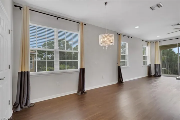 Unfurnished room featuring a chandelier, wood finished floors, and recessed lighting