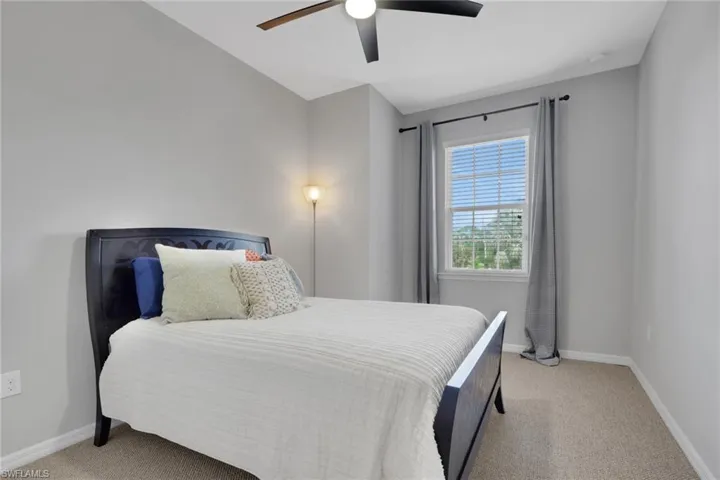 Bedroom with a ceiling fan and light carpet