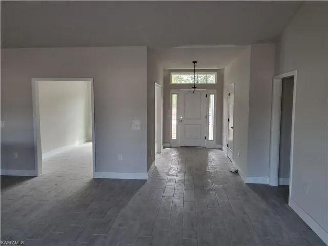 Foyer entrance featuring dark wood finished floors and baseboards
