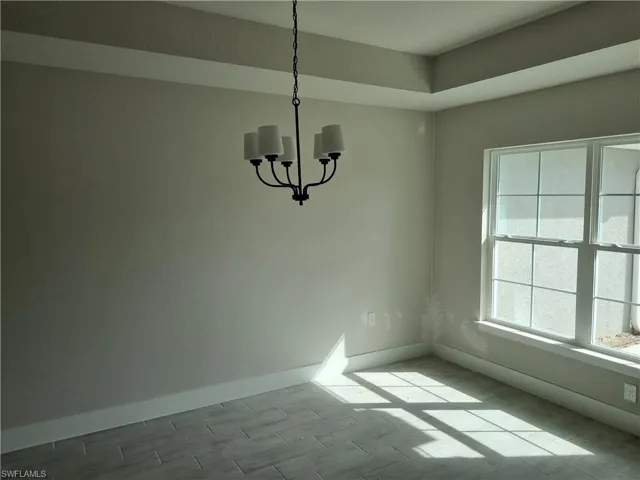 Unfurnished dining area featuring suspended lighting and wood tiled floors