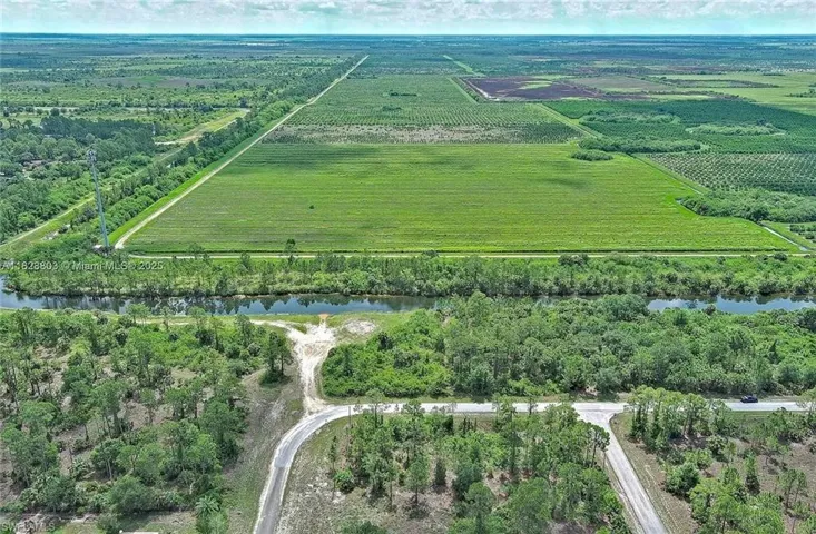 Aerial overview of property's location with extensive farmland, rural landscape, and a nearby body of water