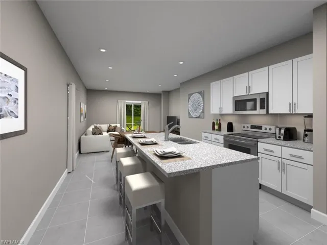 Kitchen with white cabinetry, sink, a center island with sink, and stainless steel appliances