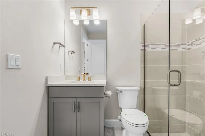 Full bathroom with vanity and a stall shower