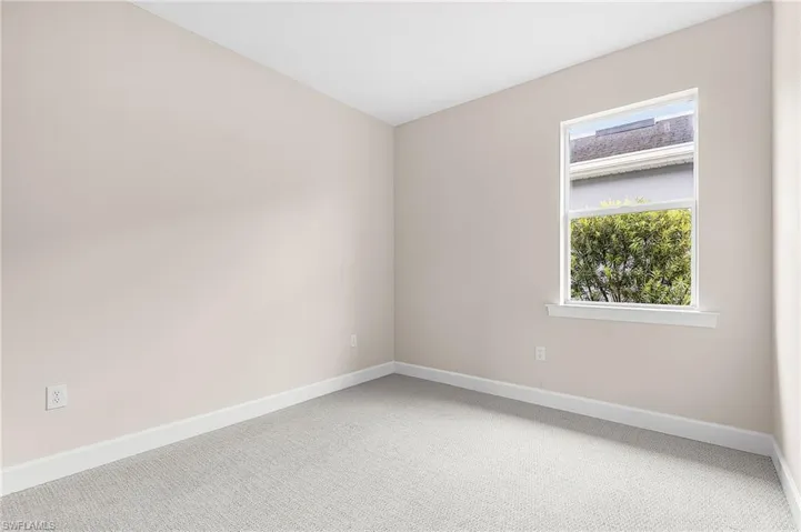 Spare room featuring light carpet and baseboards