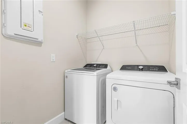 Laundry area featuring baseboards and washer and clothes dryer