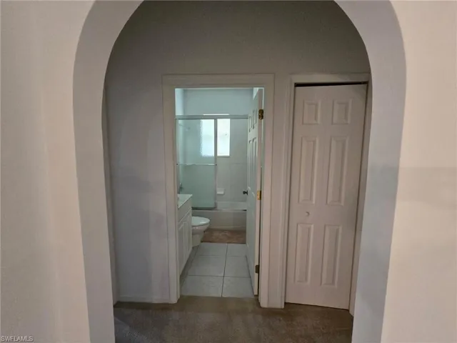 Hallway featuring light tile patterned floors