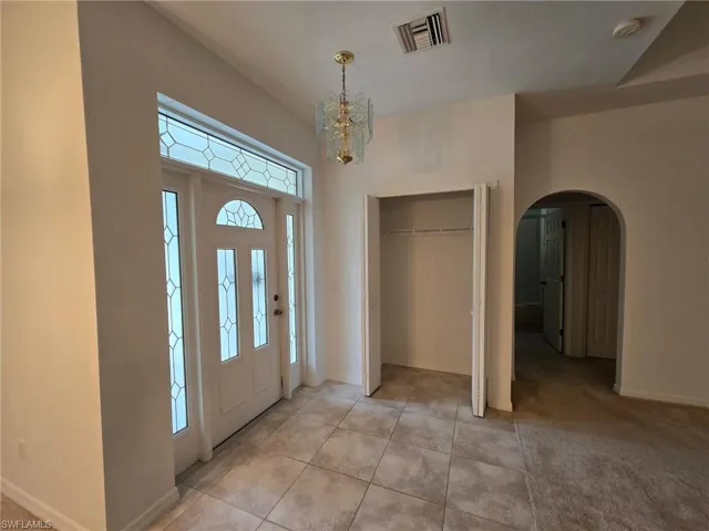 Tiled foyer with a notable chandelier