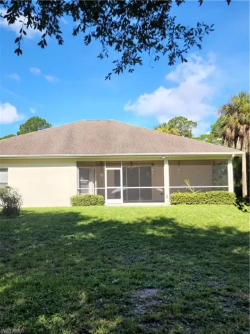 Rear view of property with a yard and a sunroom