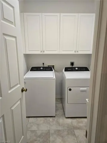Laundry room featuring cabinets and washer and dryer