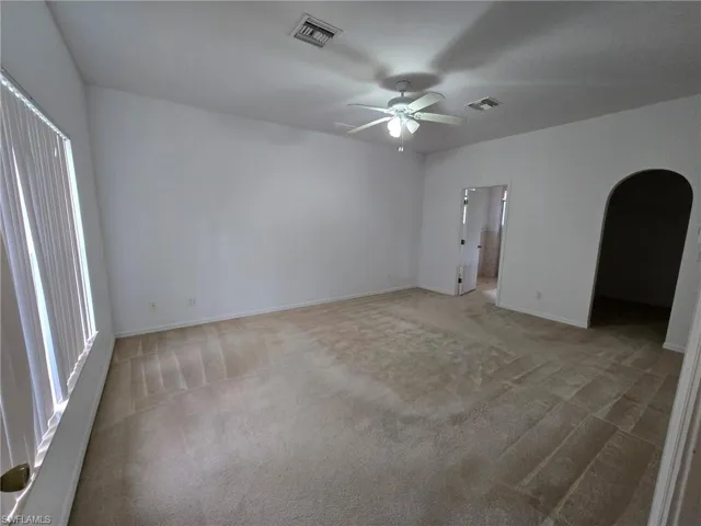 Carpeted spare room with ceiling fan