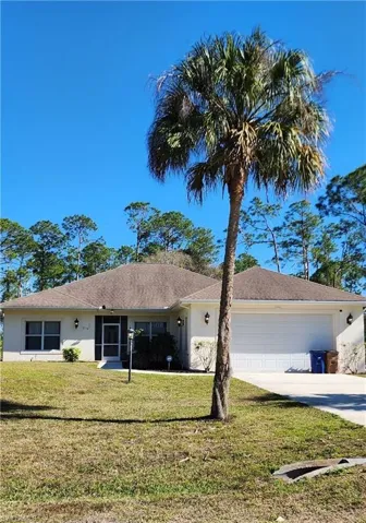 Ranch-style house featuring a front lawn and a garage