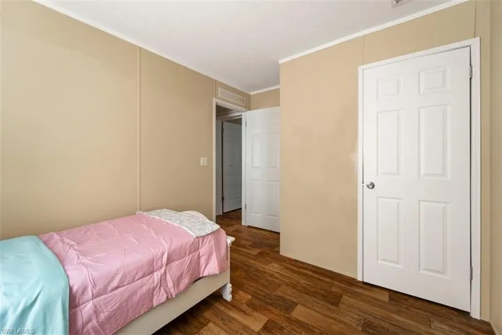 Bedroom featuring ornamental molding and dark hardwood / wood-style flooring