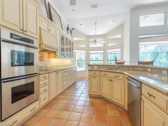 Kitchen, with breakfast bar,  opening to the great room with views of lanai and yard.