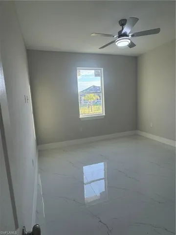 Empty room with tile flooring and ceiling fan