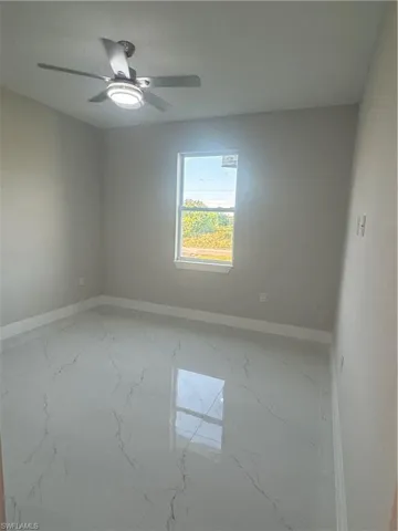 Empty room with ceiling fan and concrete flooring