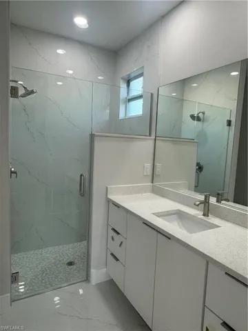 Bathroom featuring tile floors, an enclosed shower, and vanity