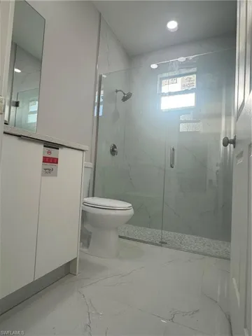 Bathroom with tile floors, walk in shower, and toilet