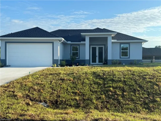 Ranch-style home featuring a garage and a front yard