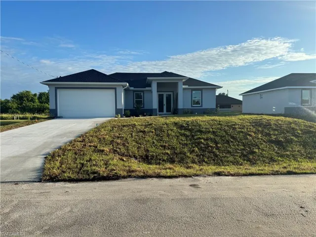 Single story home featuring a front yard and a garage