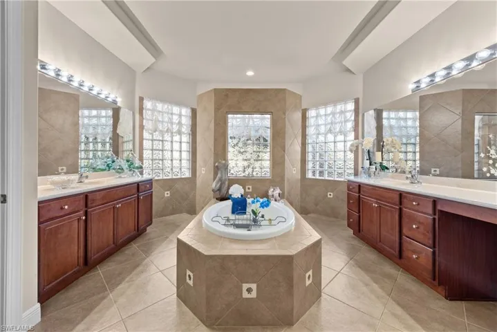 Bathroom featuring tile patterned floors, tiled tub, and tile walls