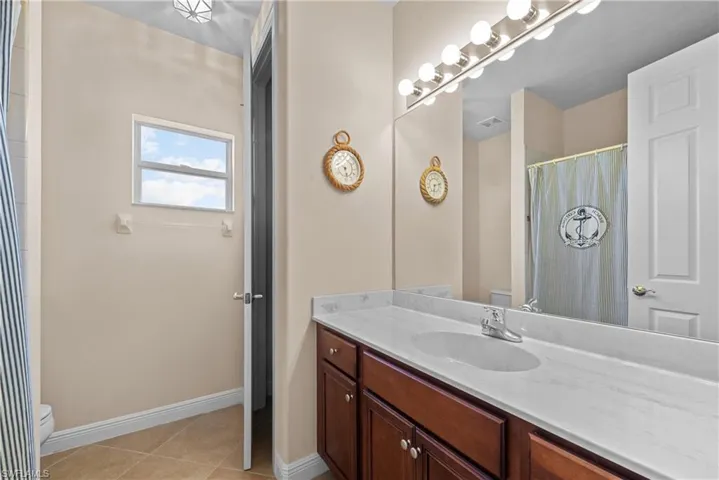 Bathroom featuring tile patterned floors, vanity, and toilet