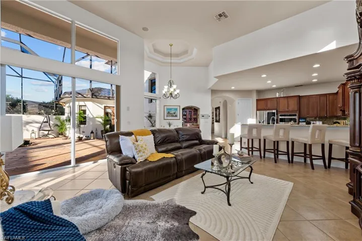 Tiled living room featuring a chandelier and a high ceiling