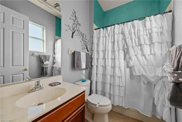 Full bathroom featuring tile patterned flooring, vanity, toilet, and shower / bath combo