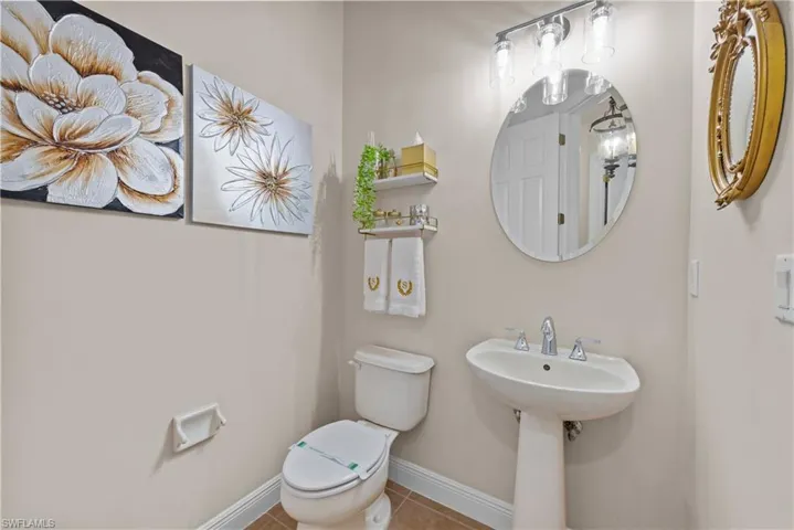 Bathroom featuring tile patterned flooring, toilet, and sink