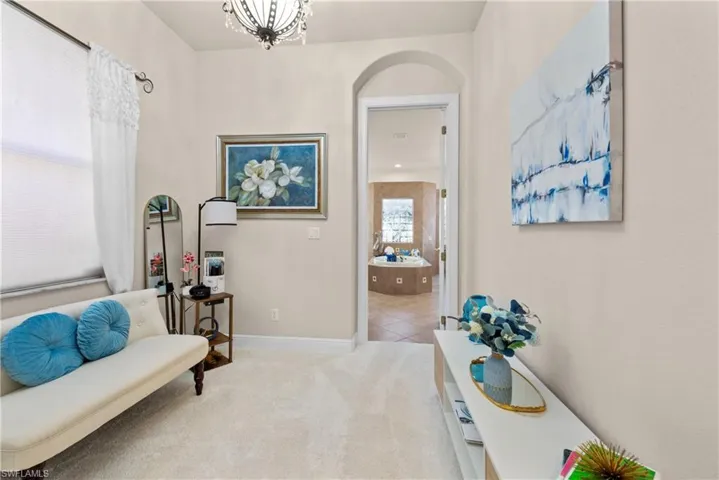 Living area featuring plenty of natural light, carpet floors, and an inviting chandelier