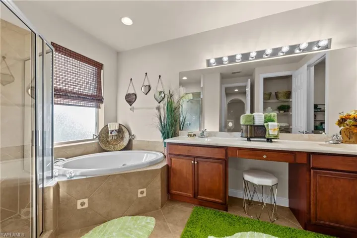 Bathroom featuring tile patterned flooring, vanity, and independent shower and bath