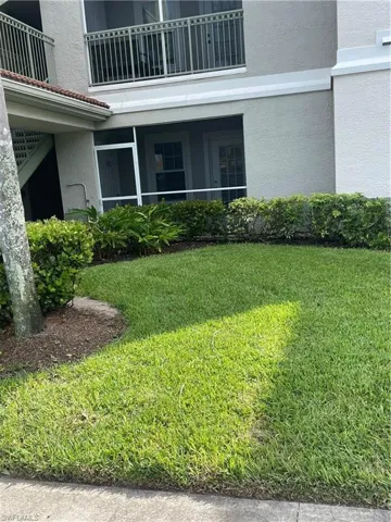 View of grassy yard with a balcony