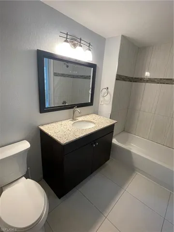 Bathroom with vanity, tile patterned flooring, and a textured wall