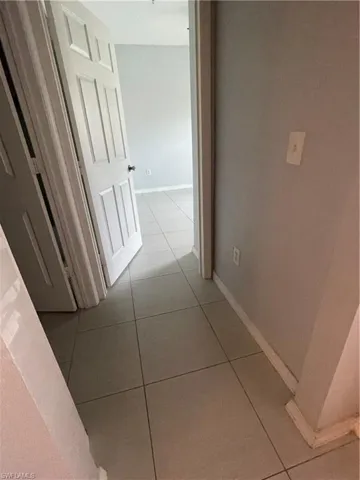 Hall with light tile patterned floors and baseboards