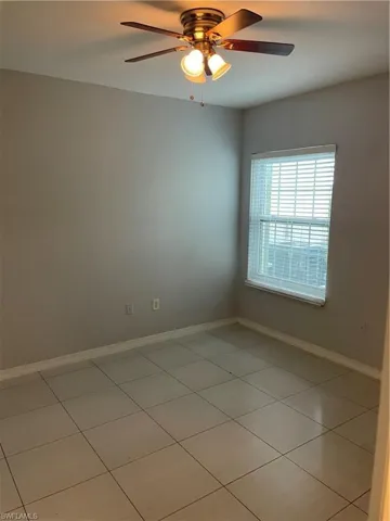 Spare room with ceiling fan and light tile patterned floors
