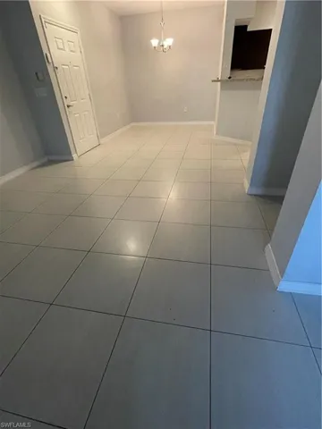 Unfurnished room with a chandelier and tile patterned floors