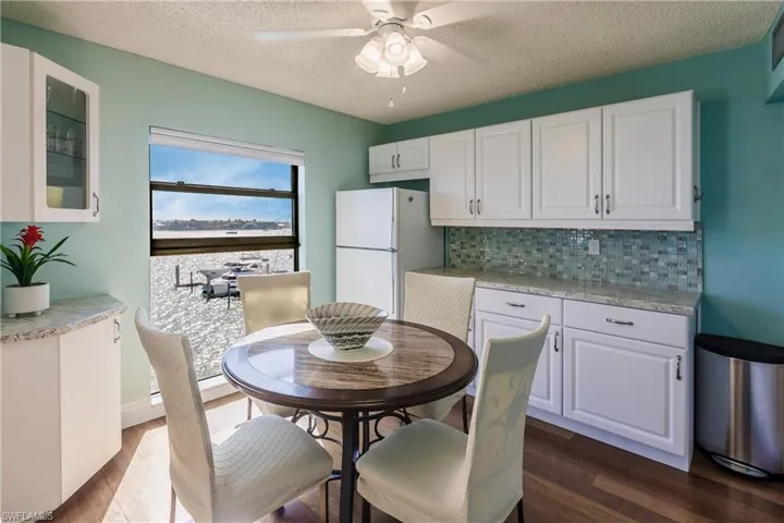 Kitchen featuring white cabinetry and white refrigerator