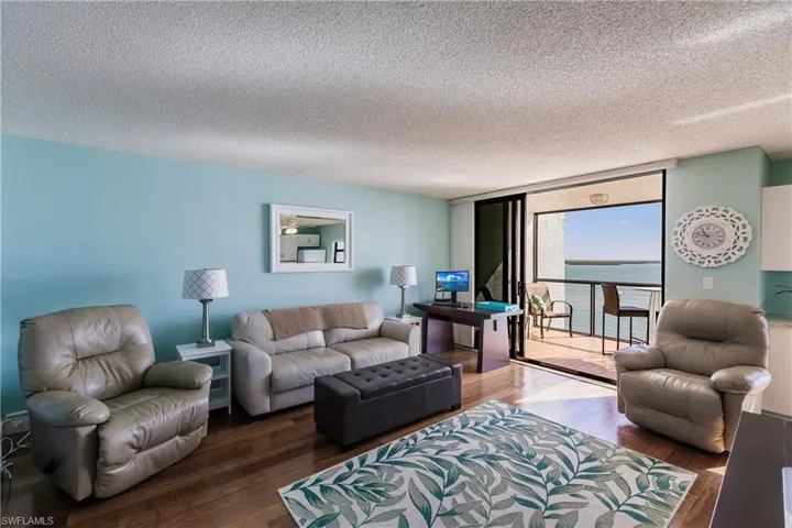 Living room featuring hardwood / wood-style flooring, a textured ceiling, and floor to ceiling windows