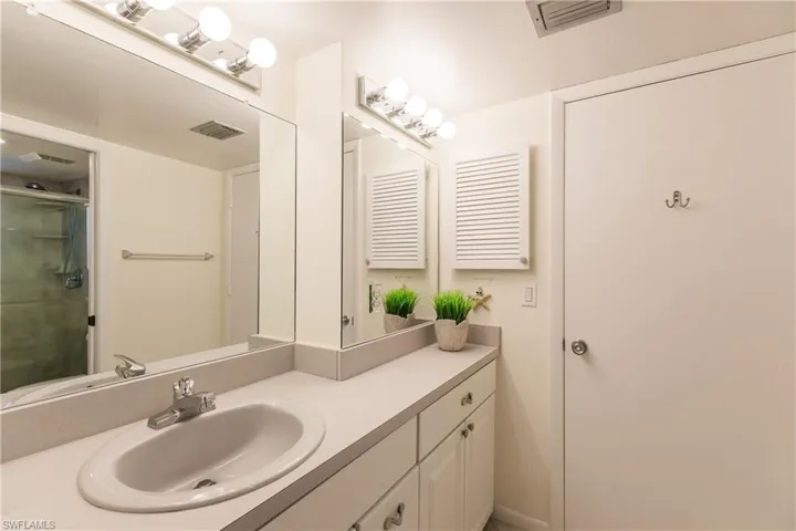 Bathroom featuring vanity and a shower with door