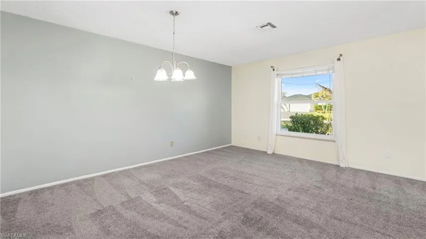 Empty room with carpet floors and hanging lights