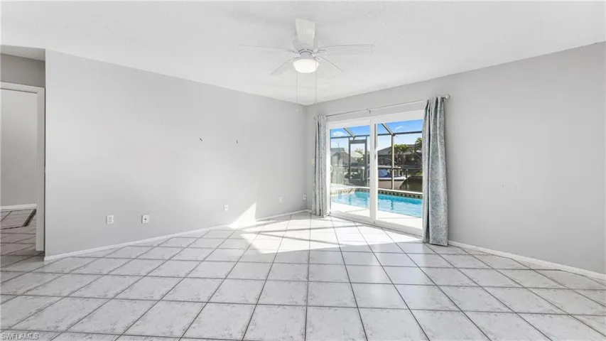 Empty room featuring a sunroom, ceiling fan, a textured ceiling, and light tile patterned floors