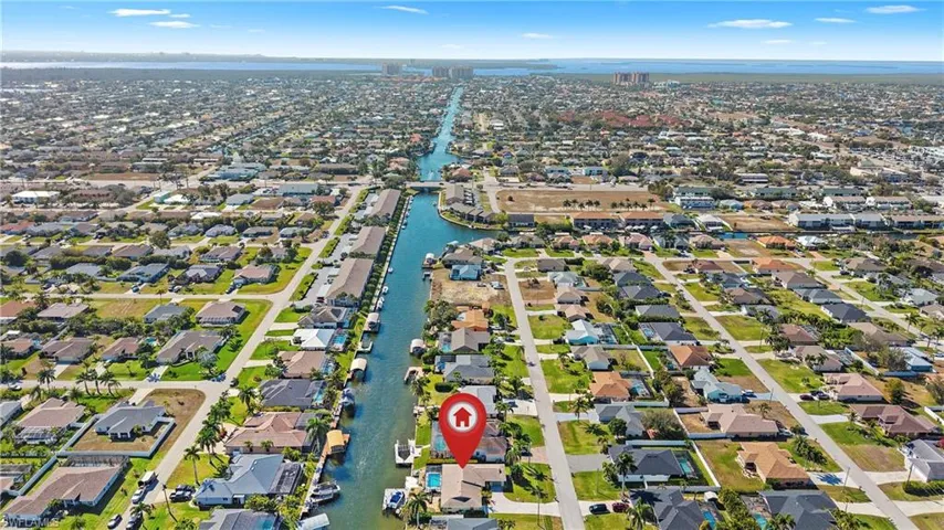 Aerial overview of property's location featuring a large body of water and nearby suburban area